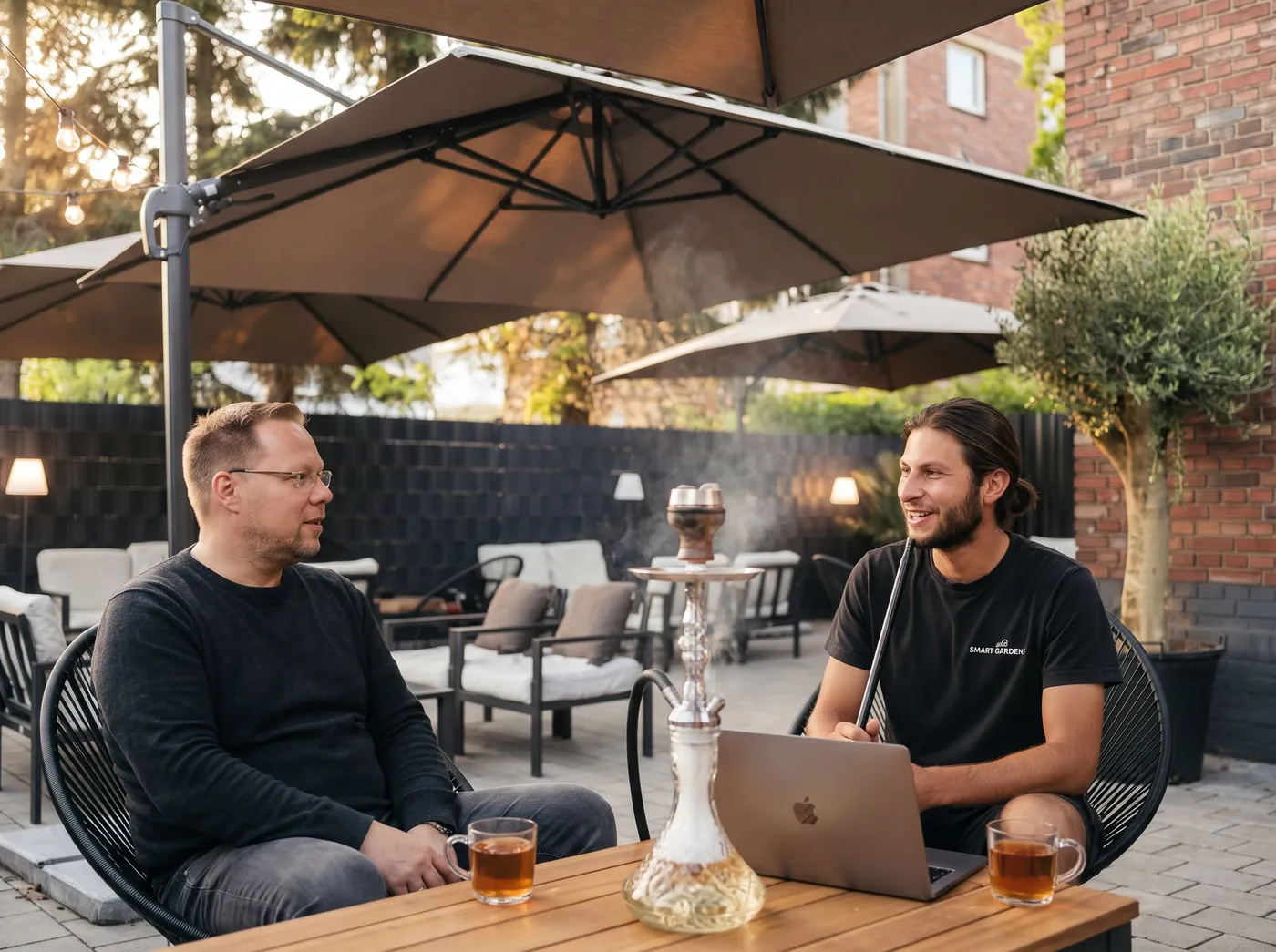 Stefan Haab und Ferid Dzaferi auf der Terrasse des Limon-Café in Duisburg, zwischen ihnen eine Shisha